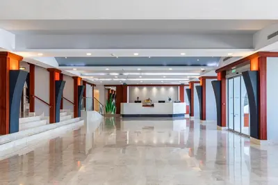 an empty lobby with orange and blue columns in a building at Belair Beach Hotel in Ixia