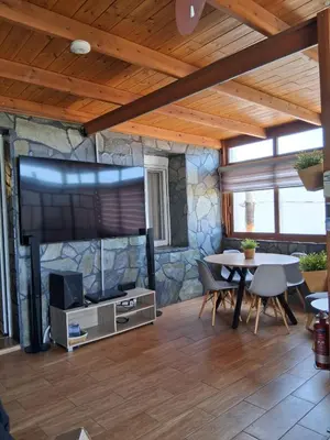 a living room with a large tv and a table at Sioutis House in Soroni