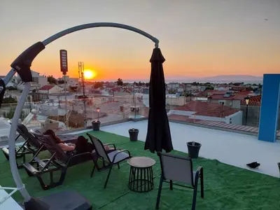 a person laying in chairs on a roof with a view at Sioutis House in Soroni