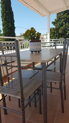 a wooden table and chairs on a patio at Theti Apartment in Faliraki