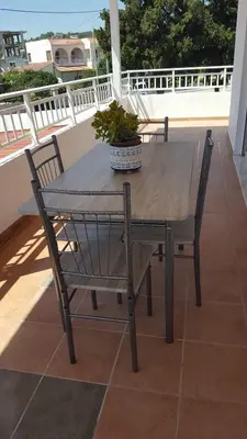 a wooden table and chairs on a balcony at Theti Apartment in Faliraki