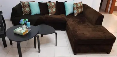 a living room with a brown couch and a table at Theti Apartment in Faliraki