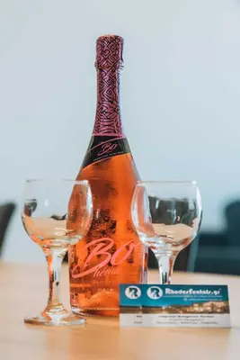 a bottle and two glasses on a table at Rhodes Port Haven Suite in Rhodes Town
