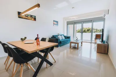 a dining room and living room with a table and chairs at Rhodes Port Haven Suite in Rhodes Town