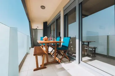 a dining room with a table and chairs on a balcony at Rhodes Port Haven Suite in Rhodes Town