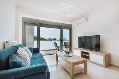 a living room with a blue couch and a television at Rhodes Port Haven Suite in Rhodes Town