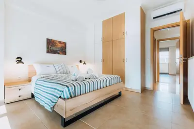 a bedroom with a bed with a blue and white blanket at Rhodes Port Haven Suite in Rhodes Town