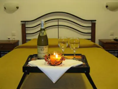 a table with a bottle of wine and two glasses at Seaside Studios Kirania in Kiotari