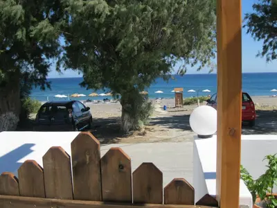 a wooden fence in front of a beach at Seaside Studios Kirania in Kiotari