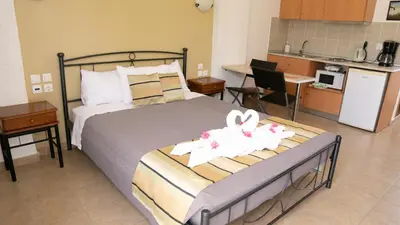 a bedroom with a bed and a small kitchen at Seaside Studios Kirania in Kiotari