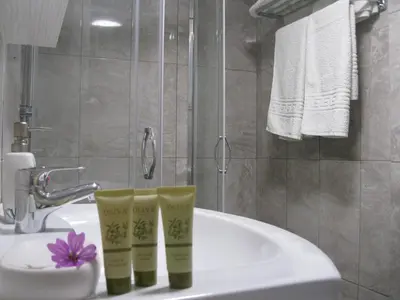 two green cups sitting on a sink in a bathroom at Seaside Studios Kirania in Kiotari