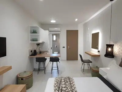 a living room and kitchen with chairs and a table at St.Thomas Beach Luxury Apartments in Pefki Rhodes