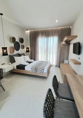 a bedroom with a bed and two chairs in it at St.Thomas Beach Luxury Apartments in Pefki Rhodes