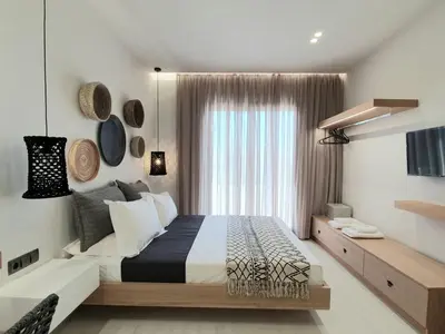 a bedroom with a large bed and a window at St.Thomas Beach Luxury Apartments in Pefki Rhodes