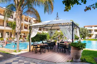 a pavilion with tables and chairs next to a pool at Villas Duc - Rhodes in Ialyssos