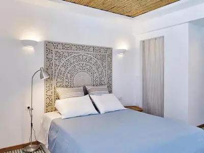a bedroom with a blue bed with a wall at KALITHEA-HILLS APARTMENT 3 in Koskinou