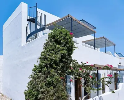 a white building with a tree on the side of it at KALITHEA-HILLS APARTMENT 3 in Koskinou