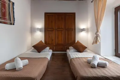 two beds in a room with towels on them at Lindos Elpis in Líndos