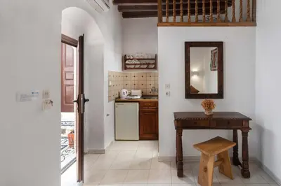 a kitchen with a table and a mirror on the wall at Lindos Elpis in Líndos