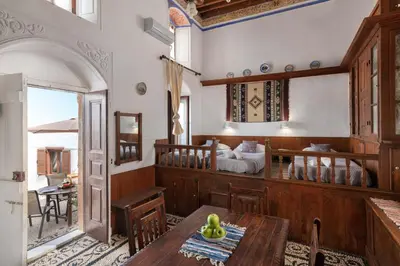 a dining room with a table and a bedroom at Lindos Elpis in Líndos