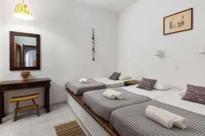 two beds in a room with a mirror and a table at Lindos Elpis in Líndos