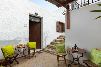 a patio with two tables and chairs and stairs at Lindos Elpis in Líndos