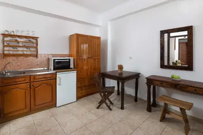 a kitchen with a sink and a table and a microwave at Lindos Elpis in Líndos