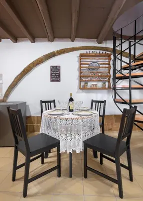 a dining room with a table with chairs and a wine bottle at RUSTIC SELF-INN in Rhodes Town