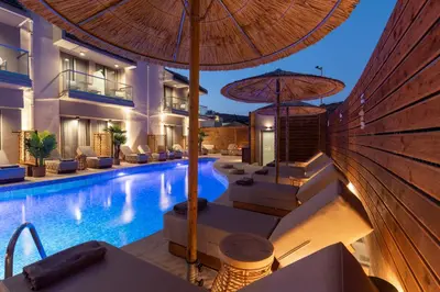 a swimming pool with an umbrella next to a hotel at Oasis Hotel Prasonisi in Prasonisi