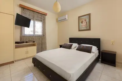 a bedroom with a large bed and a television at EvMar Villa in Rhodes Town