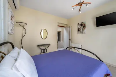 a bedroom with a purple bed and a tv at EvMar Villa in Rhodes Town
