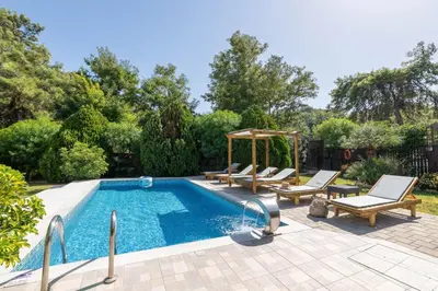 a swimming pool with chairs and a gazebo at EvMar Villa in Rhodes Town