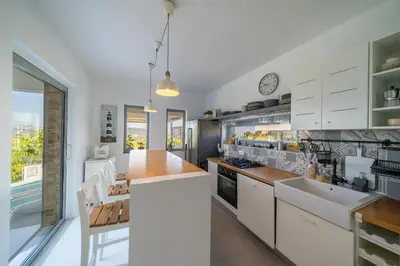 a kitchen with white cabinets and a large window at KALITHEA-HILLS VILLA with pool for 8 up to 12 IN RHODES TOWN in Rhodes Town