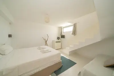 a white bedroom with a bed and stairs at KALITHEA-HILLS VILLA with pool for 8 up to 12 IN RHODES TOWN in Rhodes Town