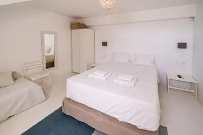a white bedroom with a large bed and a mirror at KALITHEA-HILLS VILLA with pool for 8 up to 12 IN RHODES TOWN in Rhodes Town