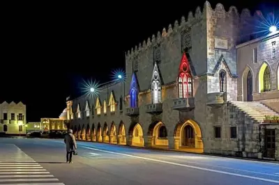 a man standing in front of a building at night at KALITHEA-HILLS VILLA with pool for 8 up to 12 IN RHODES TOWN in Rhodes Town