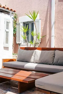 a couch sitting on a wooden bench in front of a window at Anesis Traditional Rhodian House in Kattavía
