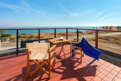 a patio with a table and two chairs on a balcony at Luxury villa in Lachania near sea in Lachania