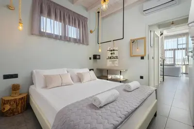 a white bedroom with a large bed with towels on it at Luxury villa in Lachania near sea in Lachania