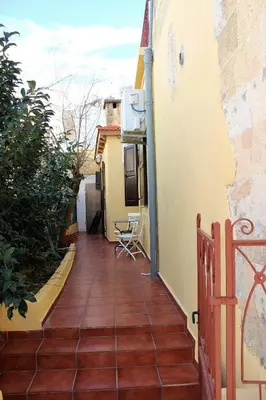 a small balcony with a wooden floor and a building at Alexandros Traditional House in Ialyssos