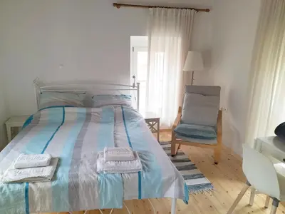 a bedroom with a bed with towels and a chair at Alexandros Traditional House in Ialyssos