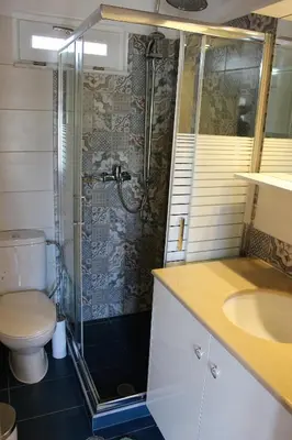 a bathroom with a shower and a toilet and a sink at Alexandros Traditional House in Ialyssos
