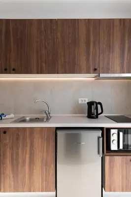 a kitchen with a sink and wooden cabinets at Nama Retreat in Pastida