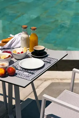 a table with a plate of fruit and juice on it at Nama Retreat in Pastida
