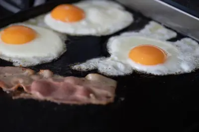 three fried eggs and bacon on a grill at Nama Retreat in Pastida