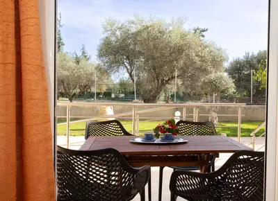 a wooden table with chairs on a patio at Villa Chelidonia Afantou in Afantou