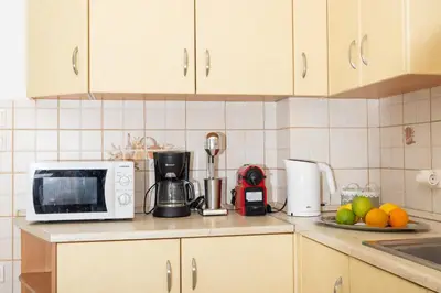 a kitchen counter with a microwave and some fruit at Villa Chelidonia Afantou in Afantou