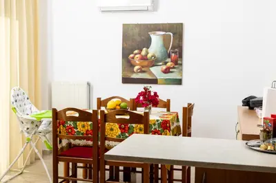 a dining room table and chairs with a painting on the wall at Villa Chelidonia Afantou in Afantou