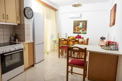 a kitchen with a refrigerator and a table with chairs at Villa Chelidonia Afantou in Afantou
