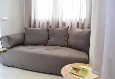a couch in a living room with a window at Haraki Endless Blue Luxury Apartments in Haraki